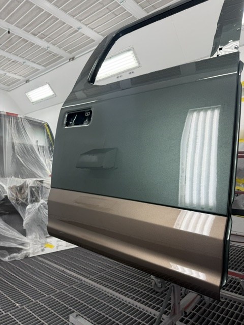 Aluminum door panel on a stand in the spray booth during refinishing