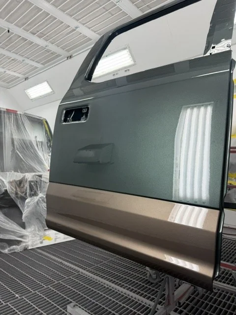Aluminum door panel on a stand in the spray booth during refinishing