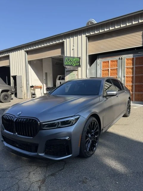 2023 BMW 750i in Frozen matte paint outside Mike Knight Customs after completed collision repair