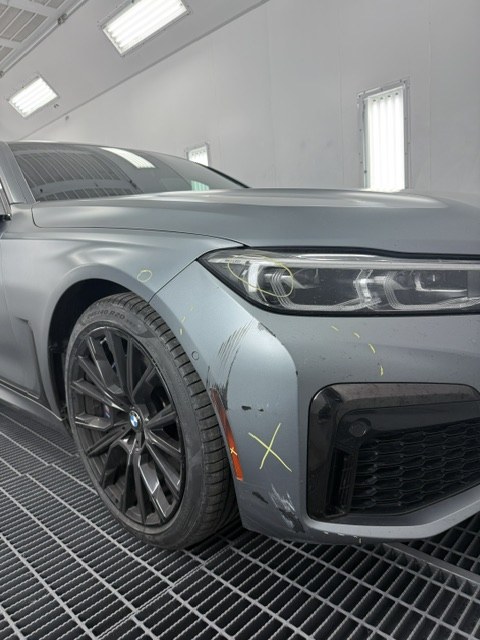 2023 BMW 750i in the shop with front collision damage marked for repair