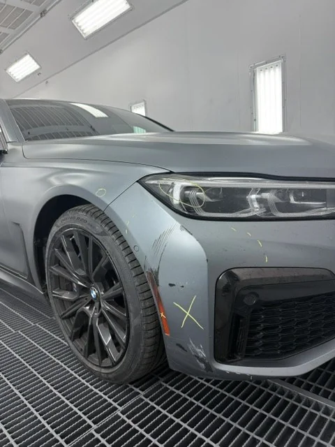 2023 BMW 750i in the shop with front collision damage marked for repair
