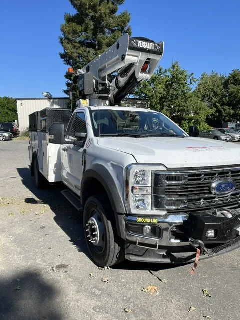 Front view of the boom truck arriving with fleet stickers on the right front corner